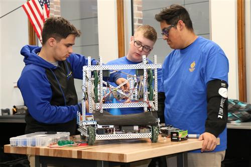 Three students work together on a robotics project